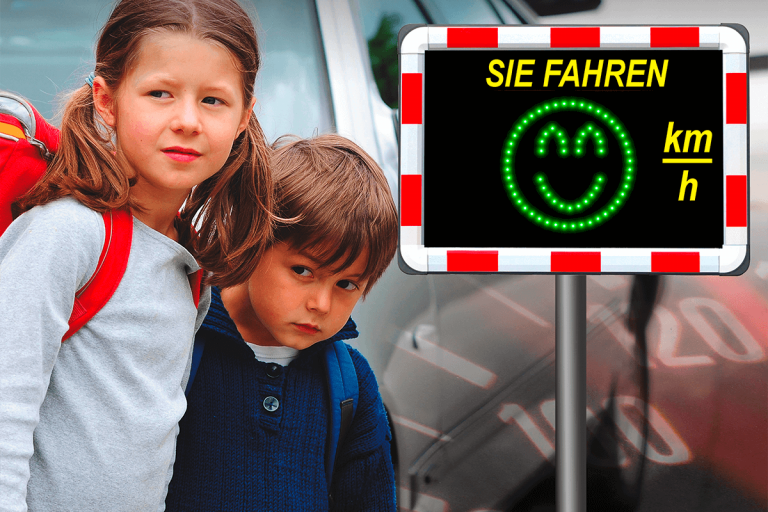 zwei Kinder die zwischen Autos hervorschauen, um zu gucken, ob die Straße frei ist, daneben befindet sich ein Geschwindigkeitsanzeiger