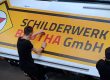 Werbetechniker Schilderwerk Beutha die gerade eine Folie bearbeiten