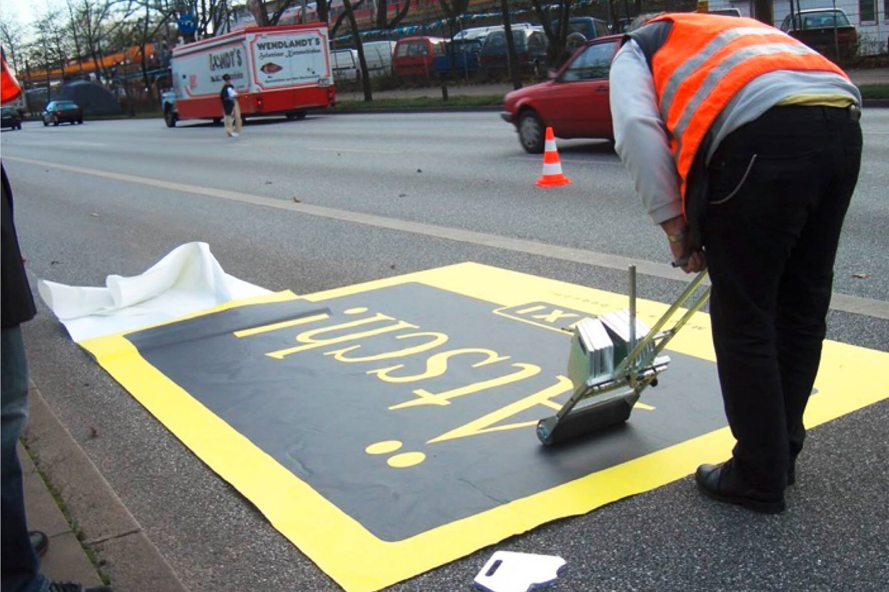 Bodenaufkleber von GECKGO 7 Momentaufnahme eines Mitarbeiters, der gerade einen Fußboden beklebt, der Bodenkleber ist beschriftet mit Ätsch!