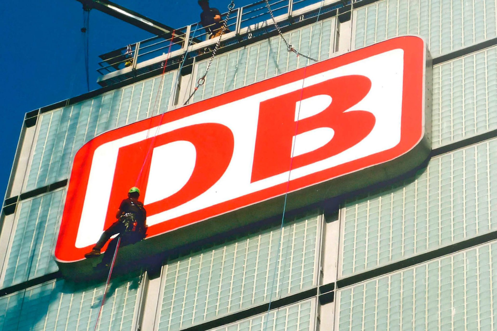 Objekt- & Firmenbeschilderung 8 Referenzbild Mitarbeiter der Schilderwerk Beutha GmbH montiert gerade das Firmen Logo der Deutschen-Bahn an ein Gebäudeobjekt