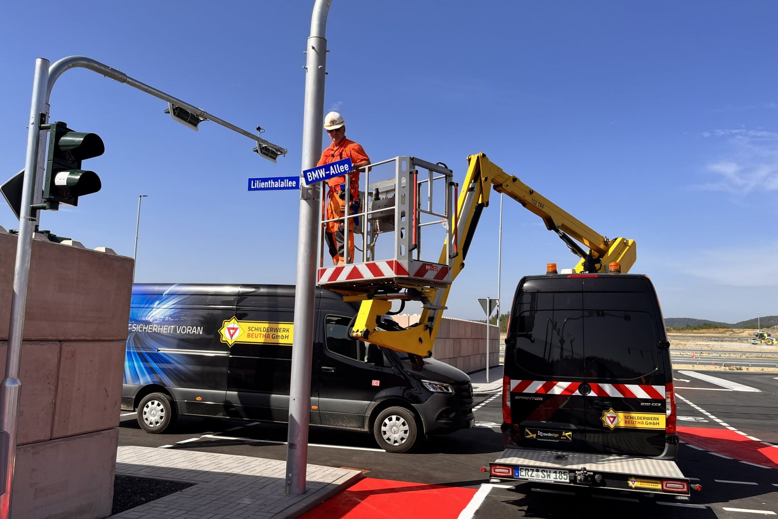 Ein Mitarbeiter der Schilderwerk-Beutha befestigt ein neues Straßenschild auf dem BMW Erprobungsgelände in Sokolov