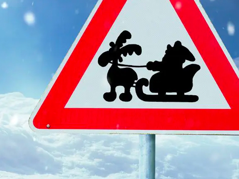 Bild indem ein Verkehrsschild mit der Beklebung von Santa Claus in seinem Schlitten zusehen ist