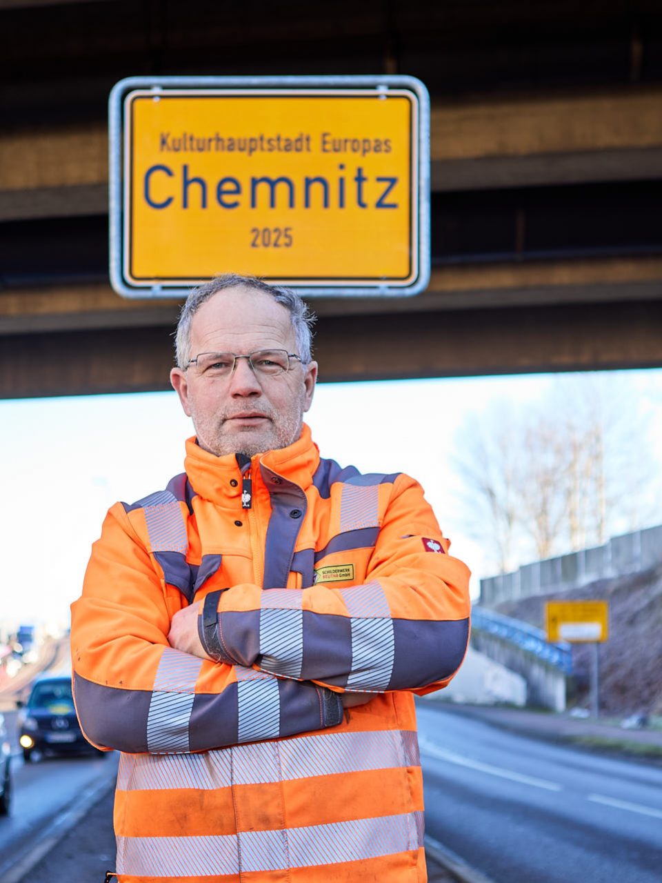 Ein Monteur des Schilderwerk Beutha vor einer Ortstafel der Stadt Chemnitz auf der Neefestraße.
