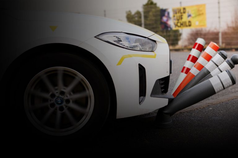 Ein Auto überfährt verschiedene Varianten unseres Märzangebotes, den überfahrbaren Pollern Pole Cone City und Traffic.