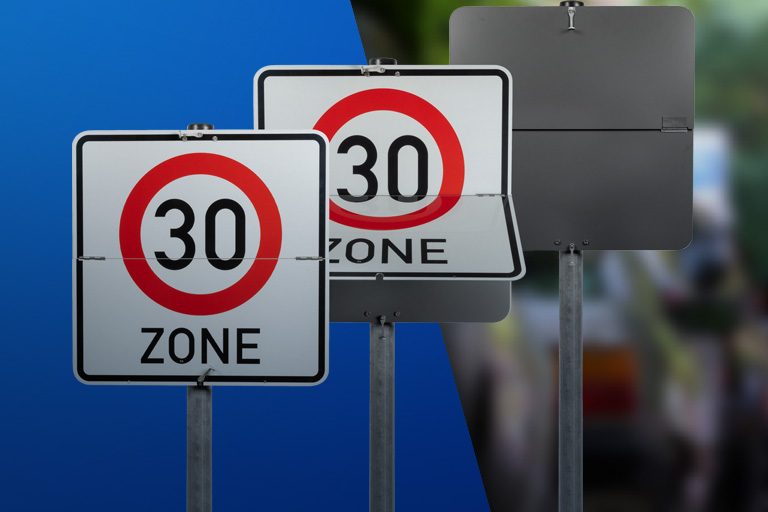 Drei Klappschilder mit dem Verkehrszeichen 30-Zone auf blauem Hintergrund nebeneinander aufgestellt