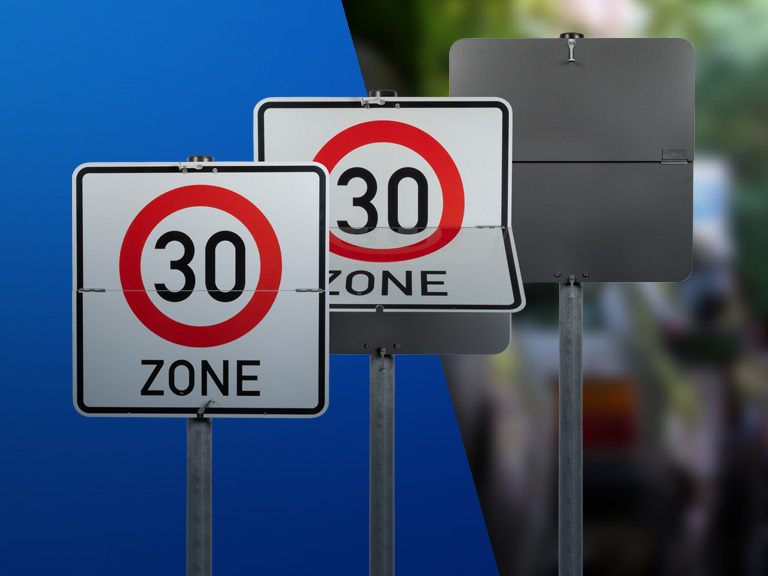 Drei Klappschilder mit dem Verkehrszeichen 30-Zone auf blauem Hintergrund nebeneinander aufgestellt