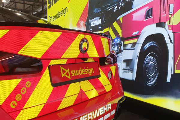 Autofolierung auf der FLORIAN 2025. Folierter Heck eines BMW steht vor der Messewand des sw/de/sign
