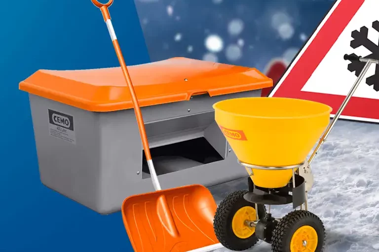 Grauer Streugutbehälter mit orangem Deckel, Schneeschaufel und gelbem Streuwagen vor Schneeflocken-Verkehrsschild