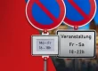 Einschubschild und Datensteckschild unter einem Halteverbotsschild mit Beispielbeschriftung auf dekorativem Hintergrund.