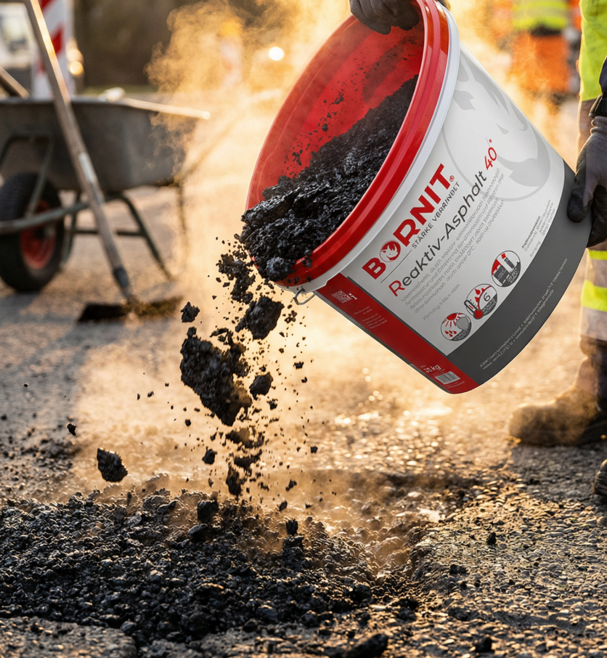 Bornit Kalt-Asphalt Asphaltmaterial wird aus einem Eimer auf eine beschädigte Straße geschüttet, dabei steigt Dampf auf