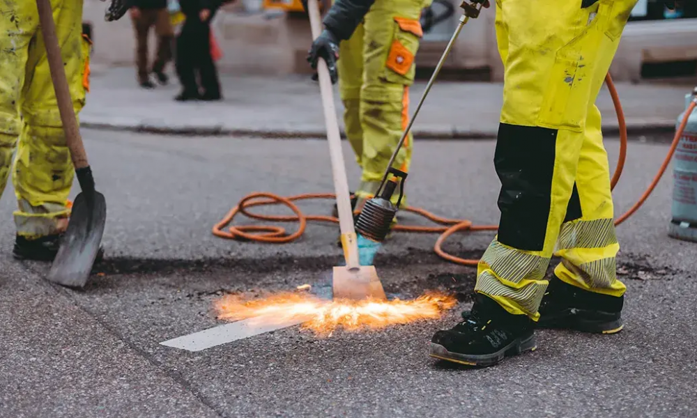 Straßenbauarbeiten mit Werkzeug und Funkenflug bei der Montage von Verkehrsinfrastruktur in Deutschland – Schilderwerk Beutha