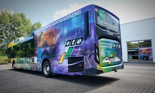 Linienbus mit großflächiger Fahrzeugfolierung und individueller Werbegestaltung auf einem Betriebsgelände.