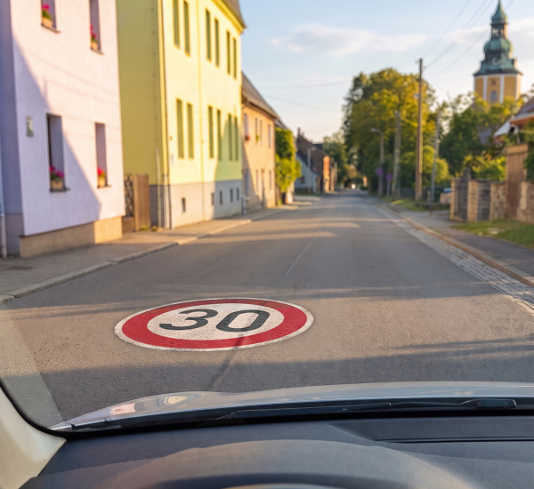 Pilotprojekt in Scheibenberg mit Tempo-30-Bodenaufkleber Blick aus einem Fahrzeug auf eine Fahrbahn mit einem Tempo-30-Bodenaufkleber in der Ortschaft Scheibenberg.