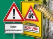 Warnschilder, Hohlkammerplakat und Raupe des Eichenprozessionsspinners.