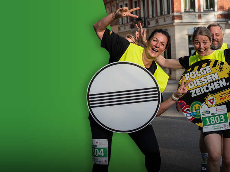 Mitarbeitende des Schilderwerk Beutha beim Firmenlauf in Chemnitz mit auffälligen Schildern und guter Stimmung.