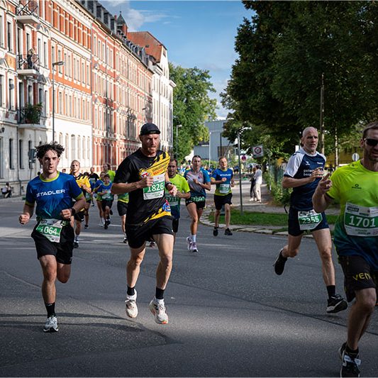 Läufer des Schilderwerk Beutha beim Firmenlauf Chemnitz 2026 inmitten weiterer Teilnehmer auf der Laufstrecke.
