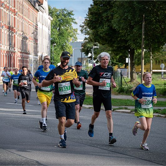 Teilnehmer des Schilderwerk Beutha läuft beim Firmenlauf Chemnitz 2026 gemeinsam mit zahlreichen weiteren Läuferinnen und Läufern durch die Stadt.