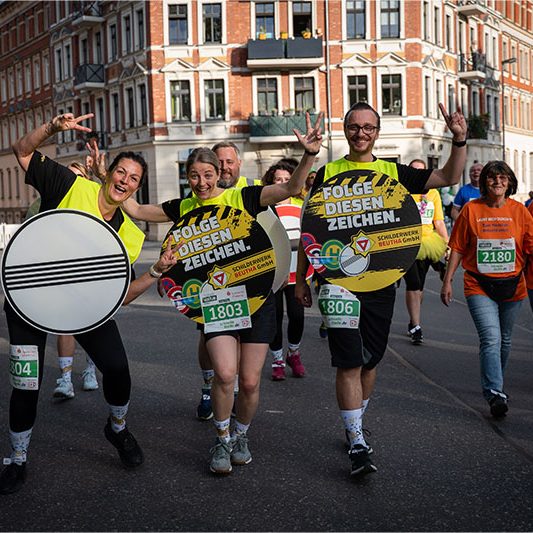 Das Schildkröten-Team des Schilderwerk Beutha beim Firmenlauf Chemnitz 2026 mit großen Verkehrszeichen und „Folge diesen Zeichen“-Motiven.